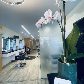 The styling floor with mirrors, leather chairs, and a fresh orchid